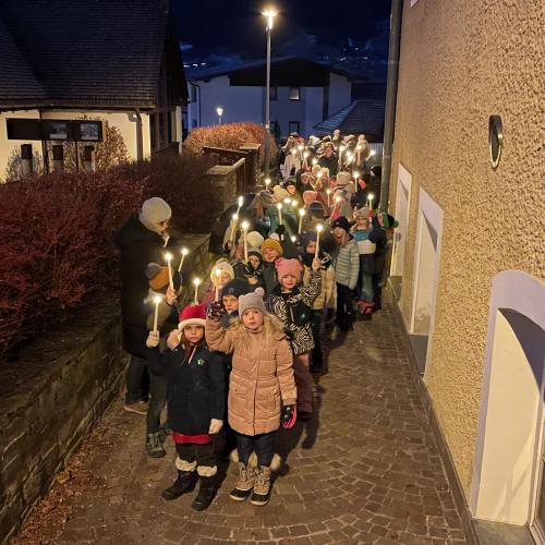 Kinder spazieren zur Bachkapelle mit Kerzen