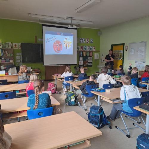 Die Kinder werden von einem Polizist über die Gefahren im Internet aufgeklärt.