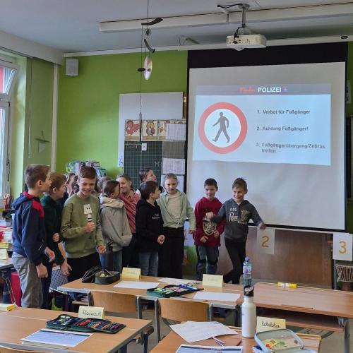 Kinder lernen etwas über Verkehrssicherheit mit einem Polizisten.