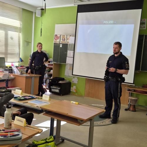 Das Polizeiteam spricht mit den Kindern über verschiedene Gefahren im Straßenverkehr.