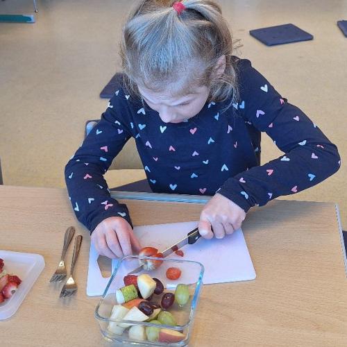 ein Kind schneidet Obst auf