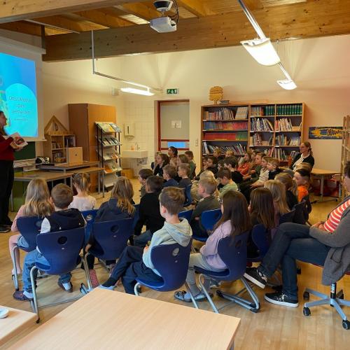 Die Kinder hören der Autorin Ruth Byrne zu.