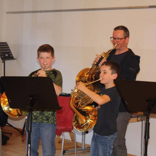 Ein Musikschullehrer spielt mit seinen Schülern ein Stück vor.