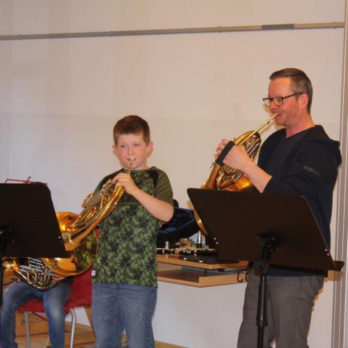 Ein Musikschullehrer spielt mit seinen Schülern ein Stück vor.