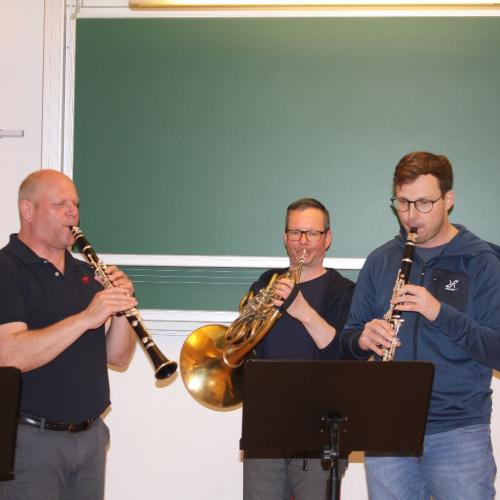 Musikschullehrer spielen auf verschiedenen Blasinstrumenten.