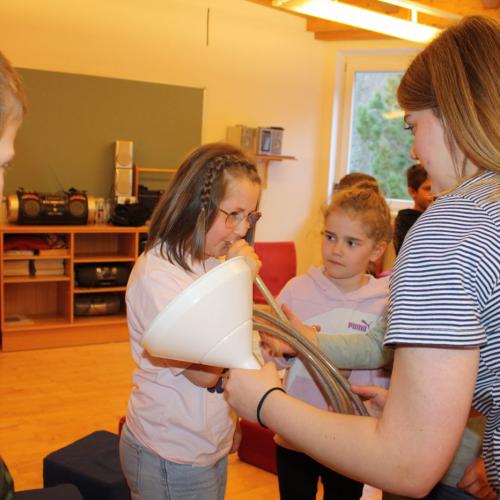 Die Kinder dürfen die selbstgebastelte Trompete ausprobieren.