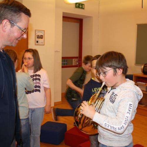 Ein Kind darf das Flügelhorn ausprobieren.