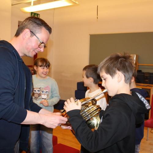 Ein Kind probiert die Trompete aus.