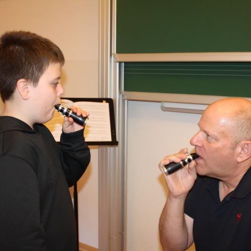 Ein Kind bläst in das Mundstück der Klarinette.