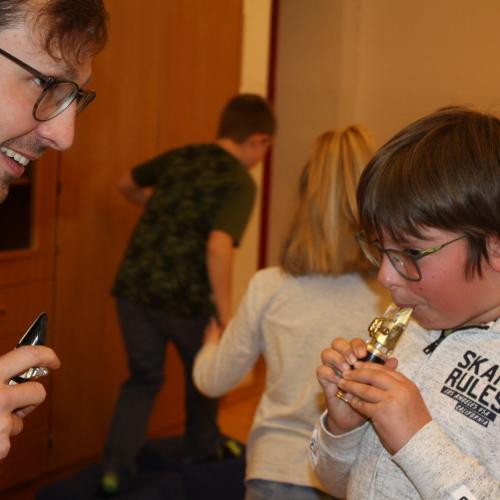 Ein Kind bläst in das Mundstück der Klarinette.