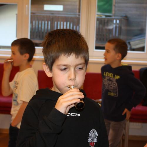 Ein Kind bläst in das Mundstück der Trompete.