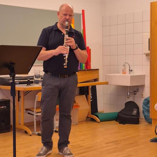 Ein Lehrer spielt auf der Klarinette vor.
