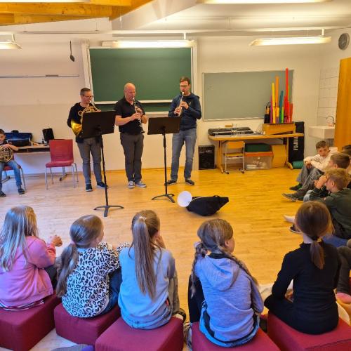 Drei Lehrer spielen auf ihren Instrumenten.