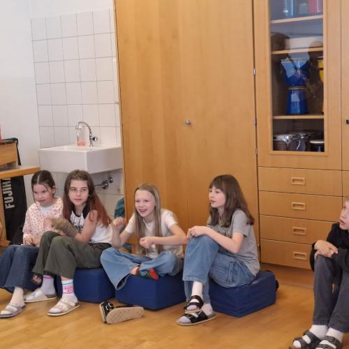 Kinder hören gespannt der Musik zu.