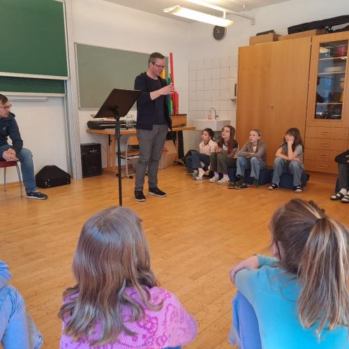 Musikschullehrer stellen Instrumenten vor.