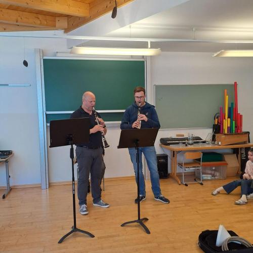 Zwei Lehrer spielen auf ihren Instrumenten.