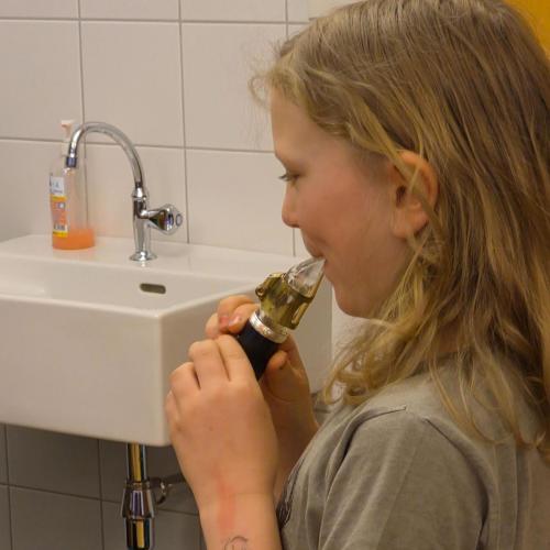 Ein Kind probiert ein Mundstücke eines Instruments aus.