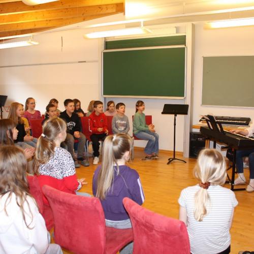 Die Kinder machen Aufwärmübungen fürs Singen.