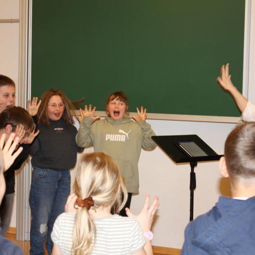 Die Kinder machen Aufwärmübungen fürs Singen.