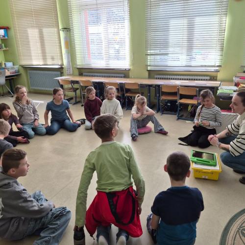 Digicoach Steffi erklärt den Kindern etwas über das Bauen von Robotern.