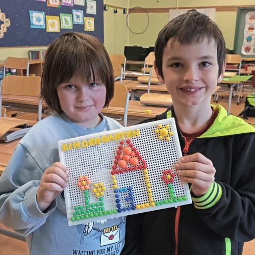 VS-Kind und Kindergartenkind zeigen ihr gemeinsam gemaltes Bild.