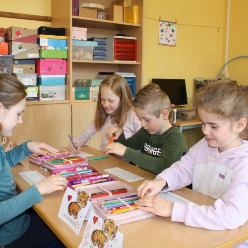 VS-Kinder zeichnen mit Kindergartenkindern in der Klasse