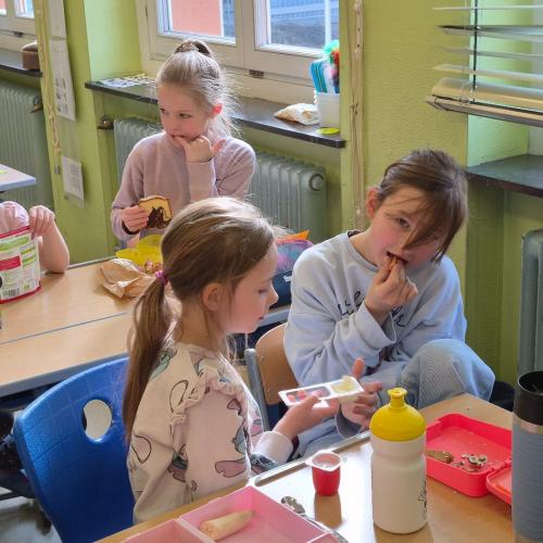 VS-Kinder mit Kindergartenkindern in der Klasse beim Jausnen