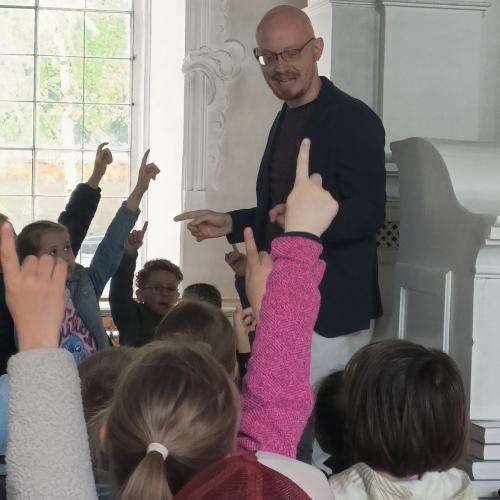 Die Kinder erfahren vom Organisten einiges über die Orgel.