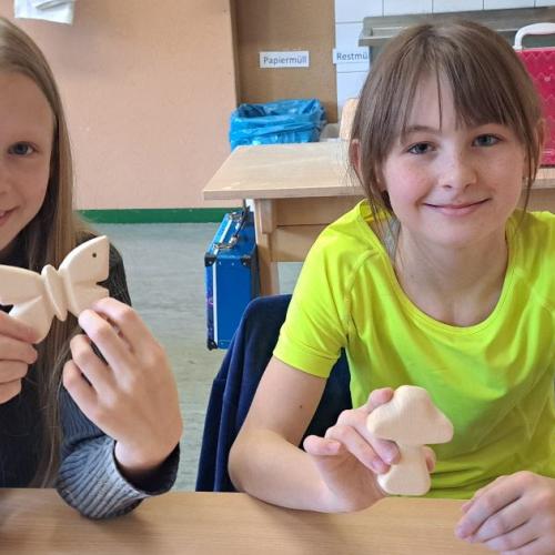 Kinder mit ihren Werkstücken aus Holz - Schmetterling, Pilz