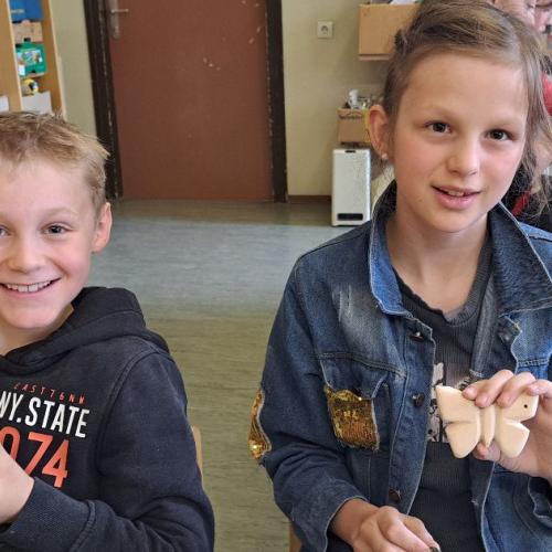 Kinder mit ihren Werkstücken aus Holz - Schmetterlingen