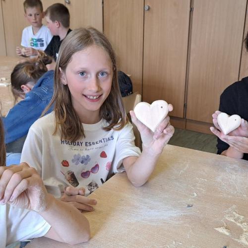 Kinder mit ihren Werkstücken aus Holz - Herzen