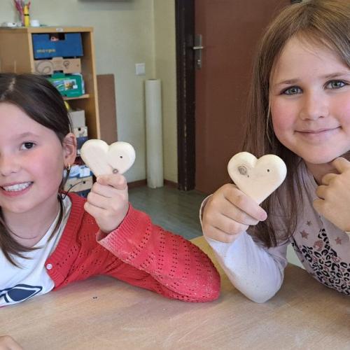 Kinder mit ihren Werkstücken aus Holz - Herzen