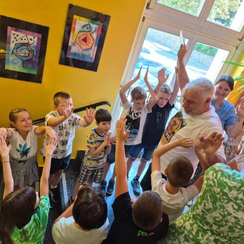 Schulwart Tom wird durch ein Spalier der Schulkinder durch das Schulhaus verabschiedet.