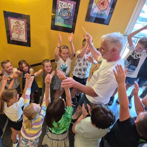 Schulwart Tom wird durch ein Spalier der Schulkinder durch das Schulhaus verabschiedet.