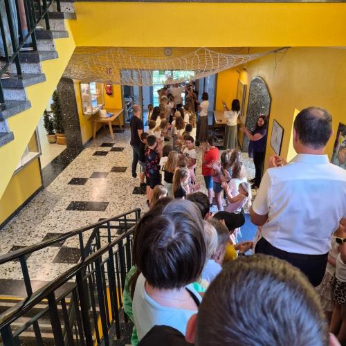 Schulwart Tom wird durch ein Spalier der Schulkinder durch das Schulhaus verabschiedet.