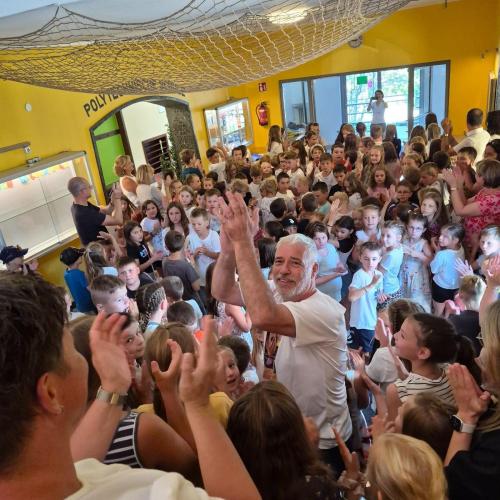 Schulwart Tom wird durch ein Spalier der Schulkinder durch das Schulhaus verabschiedet.