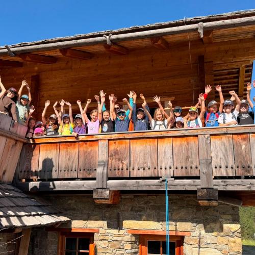 Die Kinder winken vom Balkon der Hütte.