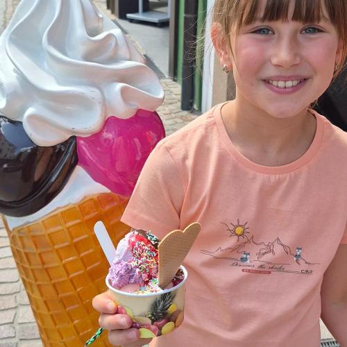 Ein Kind zeigt seinen selbstdekorierten Eisbecher.