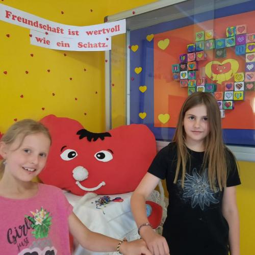 Zwei Kinder mit unserem Schulherz Benjamin.
