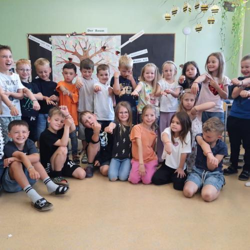 Die Kinder zeigen ihre Armbänder mit Herzanhänger.