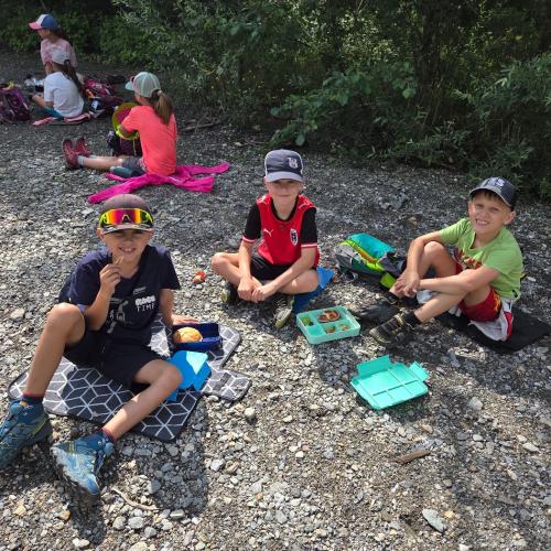 Die Kinder der 2a und der 2b jausnen beim Teich des Bretterwandbaches.