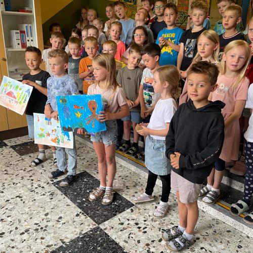 Die Kinder zeigen ihre Siegerzeichnungen.
