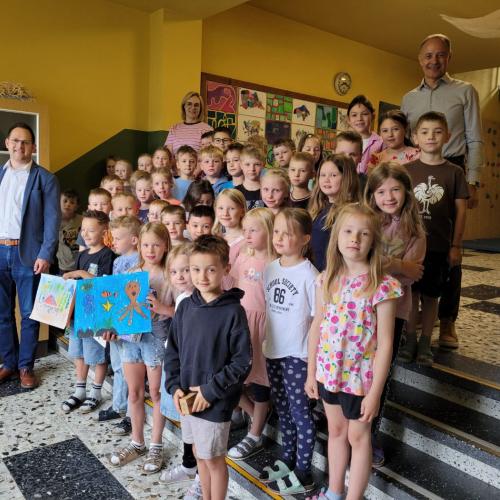 Die Kinder zeigen ihre Siegerzeichnungen.