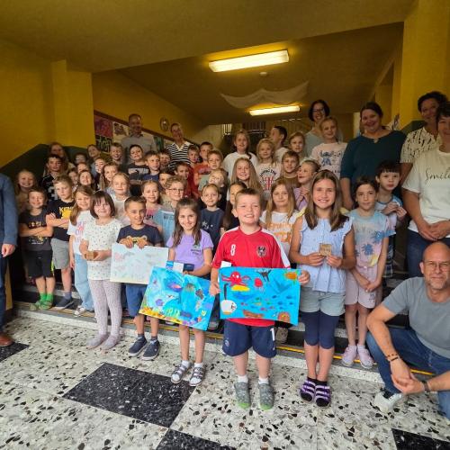 Die Kinder zeigen ihre Siegerzeichnungen.