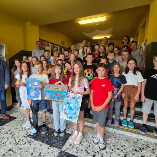 Die Kinder zeigen ihre Siegerzeichnungen.