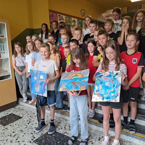 Die Kinder zeigen ihre Siegerzeichnungen.