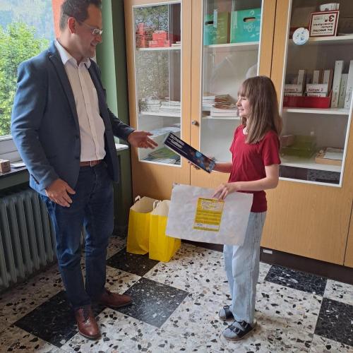 Ein Kind erhält den Preis für den gewonnenen Zeichenwettbewerb.
