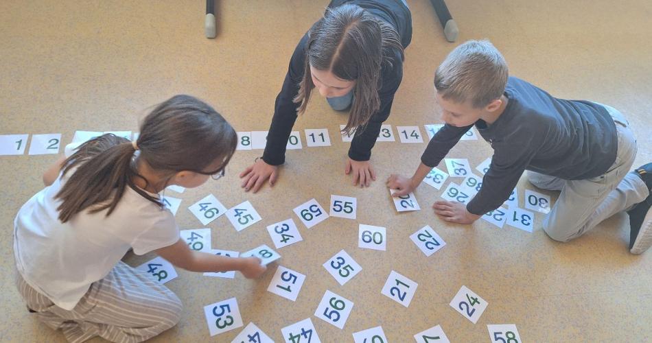 Kinder ordnen Zahlenkärtchen von 1 bis 60