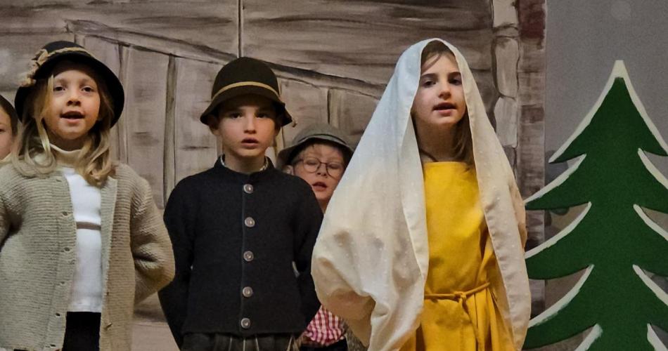 Kinder spielen ein Weihnachtsstück auf der Bühne.