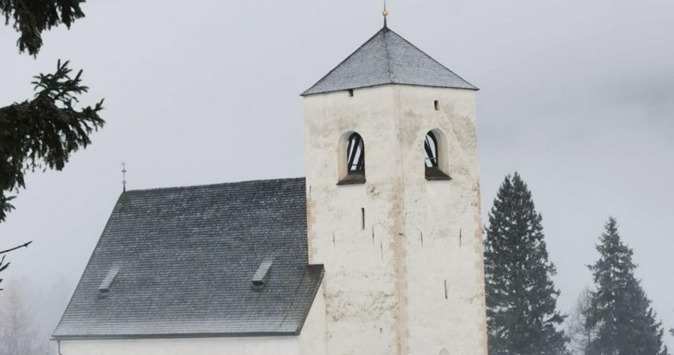 Kinder wandern durch den Schnee zur Nikolauskirche